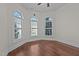 Bright bedroom featuring hardwood floors, large arched windows with shutters, and a modern ceiling fan at 1637 Hasentree Villa Ln, Wake Forest, NC 27587