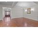 Spacious dining room with hardwood floors, elegant chandelier, and large wall mirror reflecting natural light at 1637 Hasentree Villa Ln, Wake Forest, NC 27587