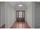 Bright foyer featuring hardwood floors, elegant lighting, and a striking wooden door with decorative glass panels at 1637 Hasentree Villa Ln, Wake Forest, NC 27587