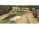 Aerial view showcasing the manicured greens, sand traps, and lush fairways of the golf course at 1637 Hasentree Villa Ln, Wake Forest, NC 27587