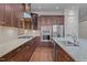 Gourmet kitchen boasts stainless steel appliances, dark wood cabinets, granite countertops, and a gas range cooktop at 1637 Hasentree Villa Ln, Wake Forest, NC 27587