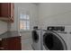 Well-equipped laundry room featuring modern washer and dryer, overhead rack, and convenient counter space at 1637 Hasentree Villa Ln, Wake Forest, NC 27587