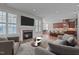 Stylish living room features a fireplace, hardwood floors, and an open layout flowing into the modern kitchen and dining area at 1637 Hasentree Villa Ln, Wake Forest, NC 27587