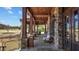 Covered outdoor patio with stone columns, seating, and views of the green at 1637 Hasentree Villa Ln, Wake Forest, NC 27587