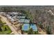 Aerial view of tennis courts, surrounded by lush trees and a clubhouse in a well-maintained community at 1637 Hasentree Villa Ln, Wake Forest, NC 27587