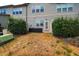 Backyard featuring small patio, partial fencing, and mature landscaping at 211 Monarda Way, Hillsborough, NC 27278