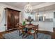 Dining room featuring hardwood floors, stylish chandelier, and adjacent open kitchen at 211 Monarda Way, Hillsborough, NC 27278