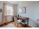 Bright home office featuring hardwood floors, a desk, and large window with decorative curtains at 211 Monarda Way, Hillsborough, NC 27278