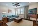 Comfortable living room with a plush sofa, wooden coffee table, ceiling fan, and natural light from shuttered windows at 211 Monarda Way, Hillsborough, NC 27278