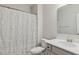 Clean bathroom featuring single vanity, framed mirror, and bathtub with white ruffled shower curtain at 217 Walker Grv Ln, Lillington, NC 27546