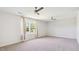 Spacious bedroom featuring carpet, two ceiling fans, and large windows with decorative curtains at 217 Walker Grv Ln, Lillington, NC 27546