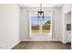 Bright dining room with a modern light fixture and large windows overlooking the backyard at 217 Walker Grv Ln, Lillington, NC 27546