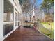 Inviting screened-in porch with an outdoor dining set, grill, and a wooded view beyond at 2309 Laurelford Ln, Wake Forest, NC 27587