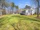 Spacious backyard with green lawn, mature trees, and a view of the home's screened-in porch at 2309 Laurelford Ln, Wake Forest, NC 27587