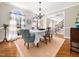 Elegant dining room with hardwood floors, chandelier, and large windows with scenic views at 2309 Laurelford Ln, Wake Forest, NC 27587