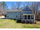Expansive backyard with a two-story home featuring a covered porch, and lush green grass at 2309 Laurelford Ln, Wake Forest, NC 27587