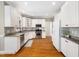 Bright kitchen with white cabinets, stainless steel appliances, and beautiful hardwood floors at 2309 Laurelford Ln, Wake Forest, NC 27587