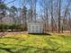 Backyard with a grey storage shed that features double doors and green grass at 2309 Laurelford Ln, Wake Forest, NC 27587
