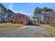 Exterior view of a brick home with parking carport and mature trees at 2311 Glover Rd, Durham, NC 27703