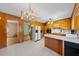 Open kitchen with adjacent dining area, featuring wood cabinetry and updated appliances at 2311 Glover Rd, Durham, NC 27703