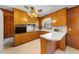 Traditional kitchen features wood cabinetry, white countertops, and ceiling fan lighting at 2311 Glover Rd, Durham, NC 27703