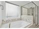 Bright bathroom boasts a soaking tub, frameless glass shower, and neutral tile at 2505 Mt Zion Church Rd Rd, Apex, NC 27502