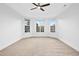 Large bedroom with neutral carpeting, tray ceiling, ceiling fan, and bright windows at 2505 Mt Zion Church Rd Rd, Apex, NC 27502