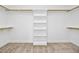Spacious walk-in closet with built-in shelving and neutral carpeting at 2505 Mt Zion Church Rd Rd, Apex, NC 27502