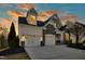 Charming home showcasing a three car garage and stone accents against a vibrant sunset backdrop at 2505 Mt Zion Church Rd Rd, Apex, NC 27502