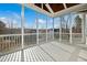 Screened-in porch with bright white wooden flooring and ceiling with views of the wooded surroundings at 2505 Mt Zion Church Rd Rd, Apex, NC 27502