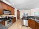 Well-lit kitchen featuring stainless steel appliances, wood cabinets, and granite countertops at 2639 Bowden Dr, Creedmoor, NC 27522