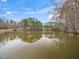 Scenic view of a tranquil lake reflecting trees under a blue sky with scattered clouds at 2639 Bowden Dr, Creedmoor, NC 27522