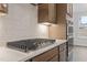 Close up of a gas cooktop and oven in a kitchen with custom backsplash at 3016 Dog Rose Dr # 303, Durham, NC 27703