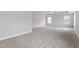 A spacious main bedroom with plush carpet and two bright windows at 3016 Dog Rose Dr # 303, Durham, NC 27703