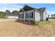 View of the side yard with manicured landscaping, light siding, and dark trim at 3131 Pilson Rd, Cameron, NC 28326
