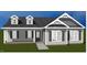 This charming home boasts dormer windows, gray siding, a welcoming porch, and professional landscaping at 3131 Pilson Rd, Cameron, NC 28326