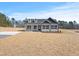 Charming new construction home featuring a manicured lawn, black shutters, and light gray siding at 3131 Pilson Rd, Cameron, NC 28326