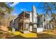 Rear of a building featuring a screened porch, outdoor seating, and a large chimney at 32 Melstone Turn, Durham, NC 27707