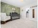 Bedroom room featuring a decorative painted accent wall, stylish crib, and a convenient walk-in closet at 325 Azalea Gaze Dr, Youngsville, NC 27596