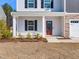 Inviting front porch with classic columns and a well-manicured front yard at 325 Azalea Gaze Dr, Youngsville, NC 27596