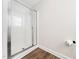 Clean glass enclosed shower stall, contrasting the modern wood look flooring and complementing the bright bathroom at 325 Azalea Gaze Dr, Youngsville, NC 27596