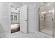 Bathroom showcasing a glass shower, marble flooring, and an open doorway to the bedroom with a ceiling fan at 3306 Leaflet Church Rd, Broadway, NC 27505