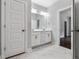 Bathroom featuring a double vanity, marble flooring, and a doorway leading to another room for added convenience at 3306 Leaflet Church Rd, Broadway, NC 27505