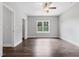 Well-lit bedroom with hardwood floors, neutral walls, ceiling fan, and a large window overlooking the outdoors at 3306 Leaflet Church Rd, Broadway, NC 27505