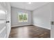 Bedroom with wood-look flooring and a view of the outdoors through a large window at 3306 Leaflet Church Rd, Broadway, NC 27505