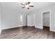 Spacious bedroom with hardwood floors, neutral walls, ceiling fan, and multiple doorways for easy access at 3306 Leaflet Church Rd, Broadway, NC 27505