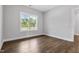 Bright, neutral bedroom featuring wood-look floors and a large window at 3306 Leaflet Church Rd, Broadway, NC 27505