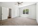 Bright bedroom features a ceiling fan, carpet, and a view to the back yard through a large window at 3328 Leaflet Church Rd, Broadway, NC 27505