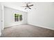 Neutral bedroom features a ceiling fan, carpet, and a large window with a view at 3328 Leaflet Church Rd, Broadway, NC 27505