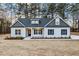 Beautiful home with a covered entry, dark shutters, professionally landscaped yard, and a long concrete driveway at 3328 Leaflet Church Rd, Broadway, NC 27505